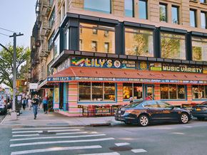 New York apartment for rent - a car parked in front of a music store on a city street