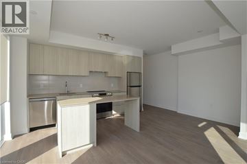 Burlington condo for rent - A well-lit kitchen with wooden cabinets and a stainless steel dishwasher.