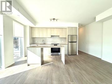 Burlington (Brant) condo for rent - A modern kitchen with a dining table and a refrigerator.
