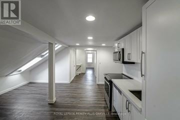 Oakville (Qe Queen Elizabeth) house for rent - A spacious kitchen with white cabinets and black countertops.