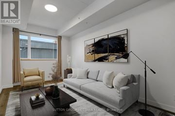 Ottawa condo for rent - A modern living room with a grey sofa, a coffee table, and a large abstract painting on the wall.