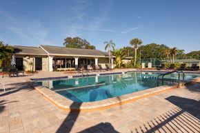 Tampa apartment for rent - a swimming pool in front of a house with a resort style pool