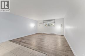Windsor apartment for rent - A large empty room with wooden flooring and a window with bars on it.