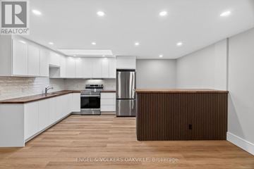 Oakville (Oo Old Oakville) house for rent - A modern kitchen with white cabinets and a wooden island.