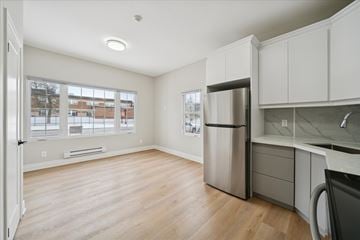 Oshawa apartment for rent - A kitchen with a refrigerator and a washing machine.