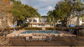 Tampa townhouse for rent - a hotel pool with chairs and a building in the background