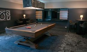 Hollywood apartment for rent - a pool table in a dark room with a chandelier