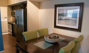Hollywood apartment for rent - a dining room with a table and chairs and a kitchen with a refrigerator