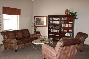 Phoenix apartment for rent - a living room with leather furniture and a book shelf
