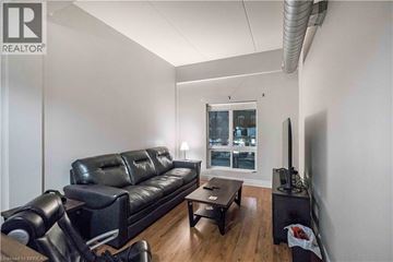 Brantford apartment for rent - A living room with a black leather couch and a television.