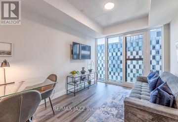Oshawa (O'neill) condo for rent - A living room with a glass table and a grey couch.