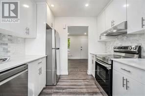 Ottawa other for rent - A white kitchen with a refrigerator and stove top oven.