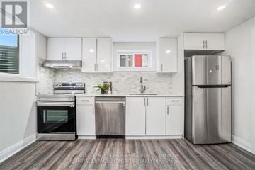 Ottawa house for rent - A modern kitchen with white cabinets and stainless steel appliances.