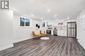 Ottawa house for rent - A modern kitchen with white cabinets and a wooden floor.