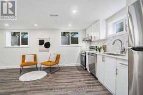 Ottawa house for rent - A kitchen with white cabinets and a black fridge.