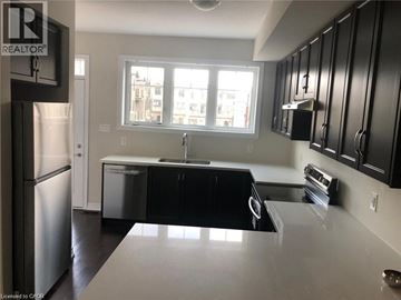 Cambridge townhouse for rent - A kitchen with black cabinets and a stainless steel refrigerator.