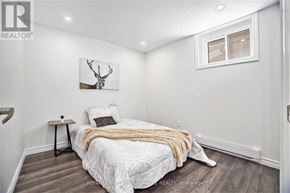 Ottawa house for rent - A bedroom with a bed, a deer head on the wall, and a window.