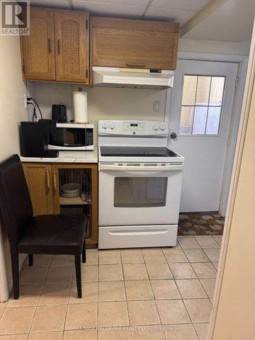 Richmond Hill (Harding) house for rent - A kitchen with a white oven and a black microwave.