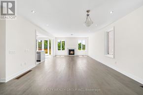 East Gwillimbury (Queensville) house for rent - A spacious room with a fireplace and a painting on the wall.