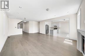 East Gwillimbury (Queensville) house for rent - A spacious living room with a fireplace and a kitchen in the background.