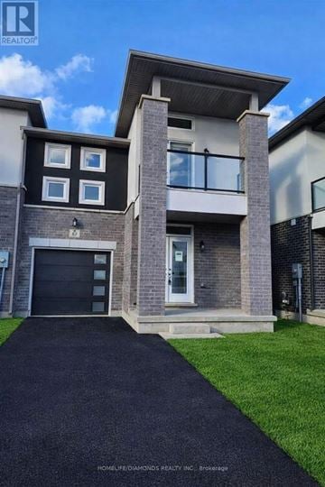 Welland (N. Welland) townhouse for rent - A modern house with a black garage door and a brick facade.