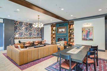 Gilbert apartment for rent - A modern living room with a large sectional sofa and a dining table set up.