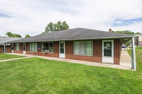 Ann Arbor apartment for rent - the front of a brick house with a lawn and a sidewalk