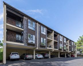 Ann Arbor apartment for rent - a parking lot in front of a building with cars parked in front