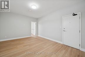 Oshawa (Central) multi-family for rent - A room with wooden flooring and white walls, with a door on the right side.