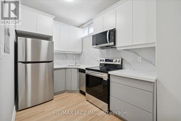 Oshawa (Central) multi-family for rent - A kitchen with white cabinets and a stainless steel refrigerator.