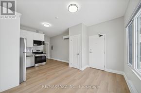 Oshawa (Central) multi-family for rent - A spacious kitchen with white cabinets and a wooden floor.