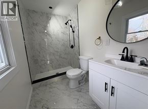 Windsor apartment for rent - A bathroom with a marble shower and white toilet.