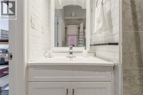 Hamilton house for rent - A white bathroom with a sink and mirror.