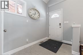 Hamilton house for rent - A white door is in a room with a clock on the wall.