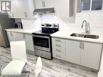 Mississauga (East Credit) house for rent - A modern kitchen with white cabinets and a marble backsplash.