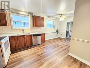 Mississauga (Erin Mills) house for rent - A kitchen with wooden cabinets and a white stove top oven.