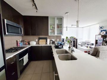 Burnaby apartment for rent - A kitchen with brown cabinets and a white counter.