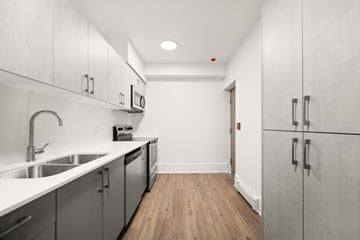 Winnipeg apartment for rent - A kitchen with white cabinets and a wooden floor.