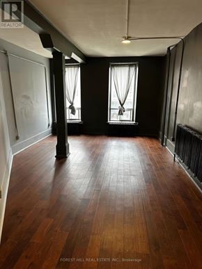 For rent in Belleville (Belleville Ward) - A room with wooden floors and two windows.
