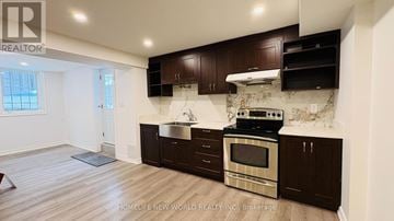 Newmarket (Armitage) house for rent - A kitchen with dark brown cabinets and a stove top oven.