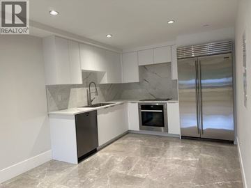 West Vancouver house for rent - A modern kitchen with a marble backsplash and stainless steel appliances.
