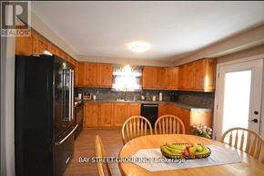 Mississauga (Erin Mills) house for rent - A kitchen with wooden cabinets and a black refrigerator.