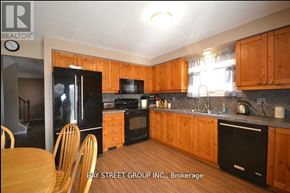 Mississauga (Erin Mills) house for rent - A kitchen with wooden cabinets and black appliances.