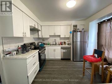 London East (East H) townhouse for rent - A kitchen with white cabinets and a stainless steel refrigerator.