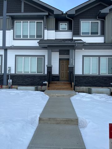 Leduc apartment for rent - A house with a brown door and a snow-covered ground.
