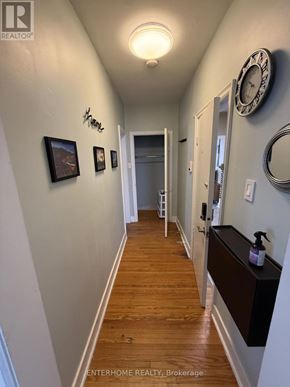 Brampton (Downtown Brampton) condo for rent - A hallway with a clock on the wall and a wooden floor.