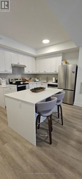 Kawartha Lakes (Fenelon Falls) condo for rent - A modern kitchen with a white island and stainless steel appliances.