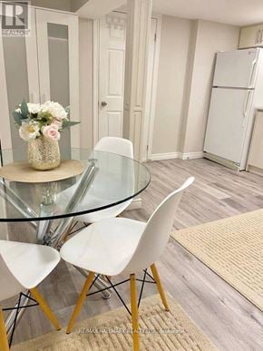 Richmond Hill (Crosby) house for rent - A glass table with a vase of flowers on it and four chairs around it.
