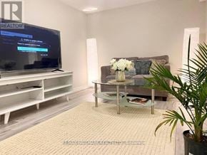 Richmond Hill (Crosby) house for rent - A living room with a grey couch, a coffee table, and a flat screen TV.