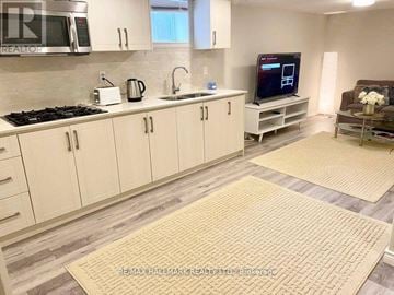 Richmond Hill (Crosby) house for rent - A kitchen with white cabinets and a tile backsplash.
